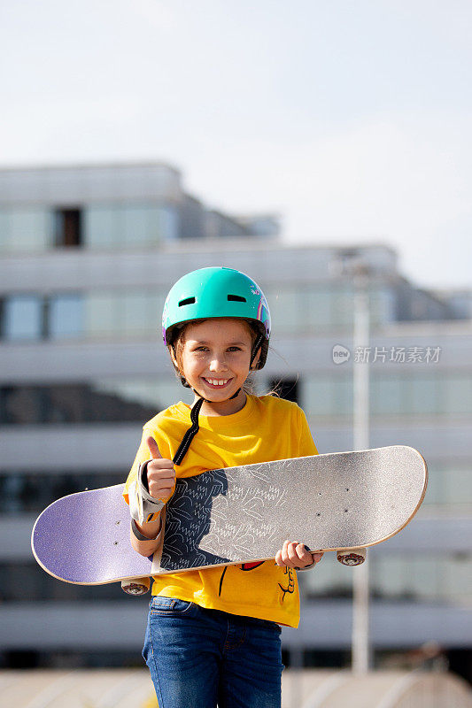 年轻的微笑滑板女孩户外