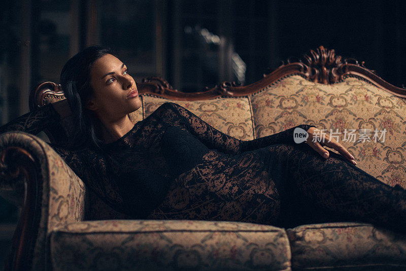 穿着黑衣服的漂亮女人躺在沙发上