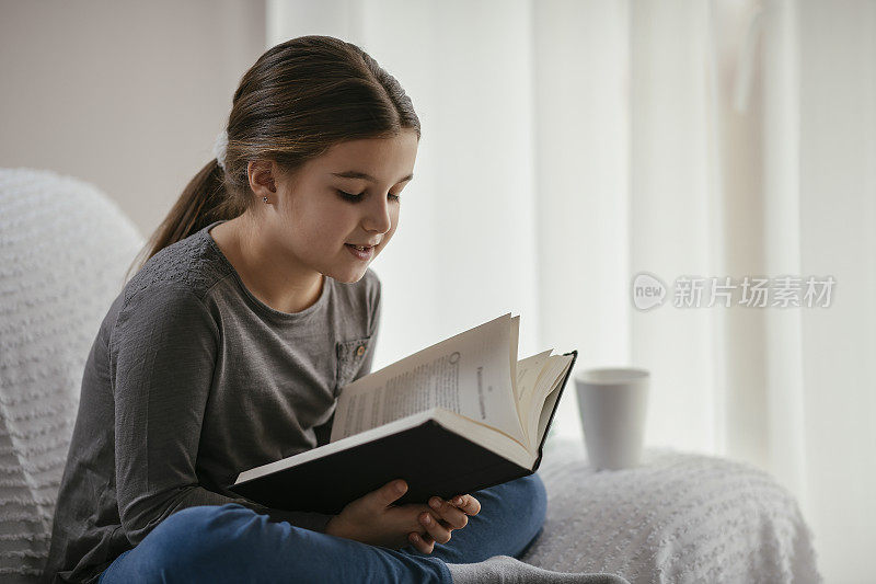 一个十几岁的女孩在客厅看书