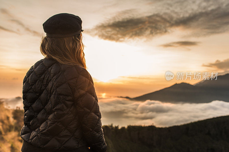 女士在山上欣赏令人惊叹的日落