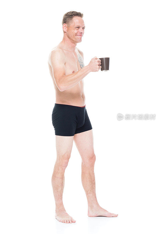 一个穿着内衣的男人拿着一个咖啡杯