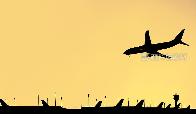 飞行剪影的商业客机在机场和黄昏的天空