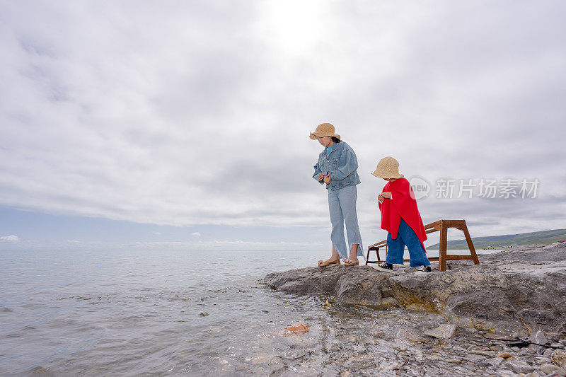 两姐妹在湖边喂鱼