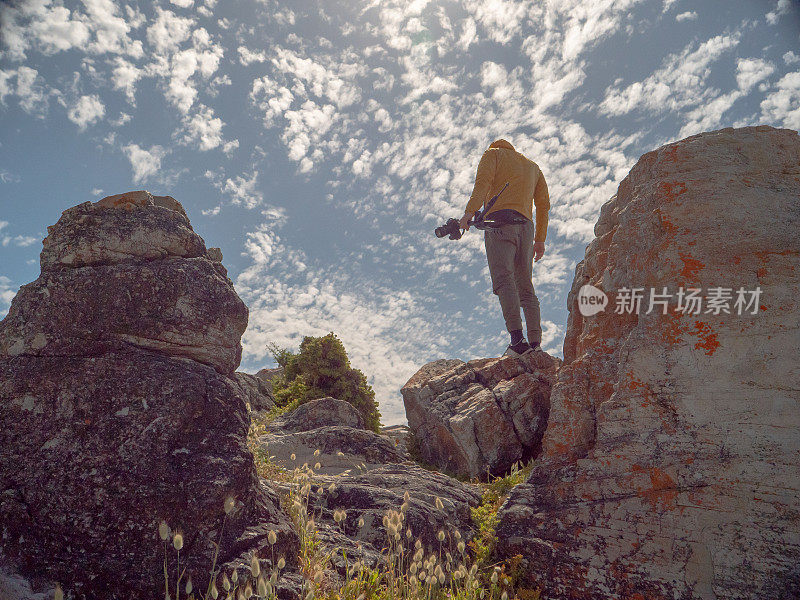 人类坐在岩石上拍摄风景照片