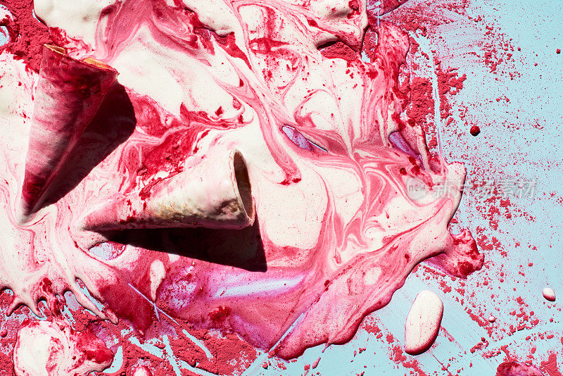 覆盆子冰淇淋融化。俯视图的空华夫筒和融化的冰淇淋与粉红色的粉末创造美丽的图案