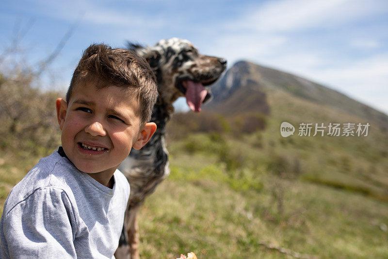 一个男孩和他的狗在徒步旅行中吃零食