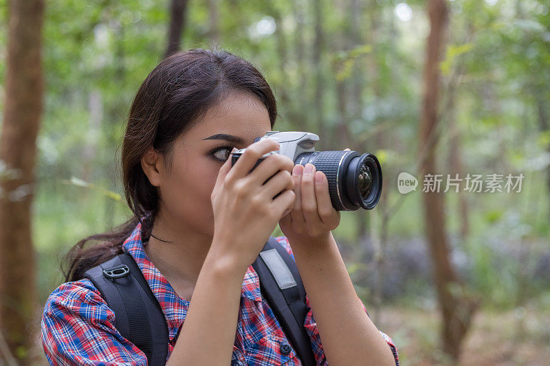 照片的摄影师亚洲女人拍照与数码单反相机专业摄影期间，她的假期，概念的女人独自旅行
