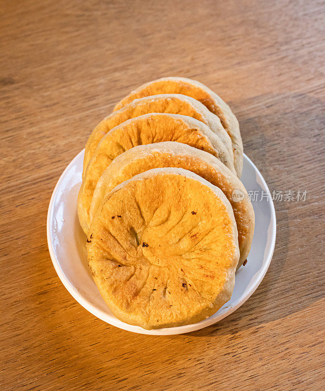 桌上有中国食物:小圆面包，馅饼。韭菜饼