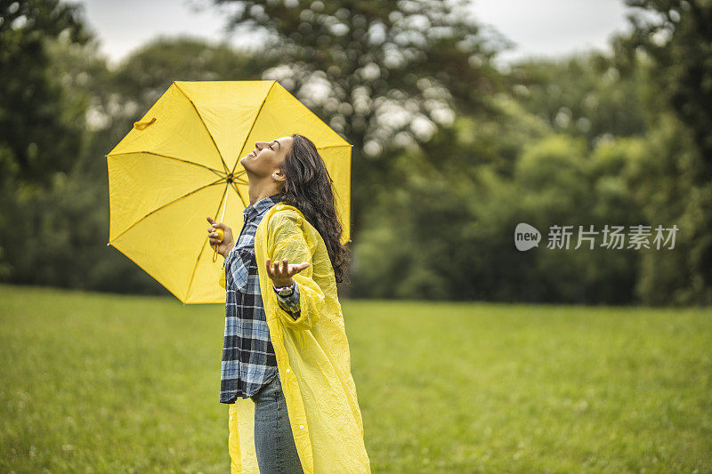 快乐的女人微笑着行走在雨天