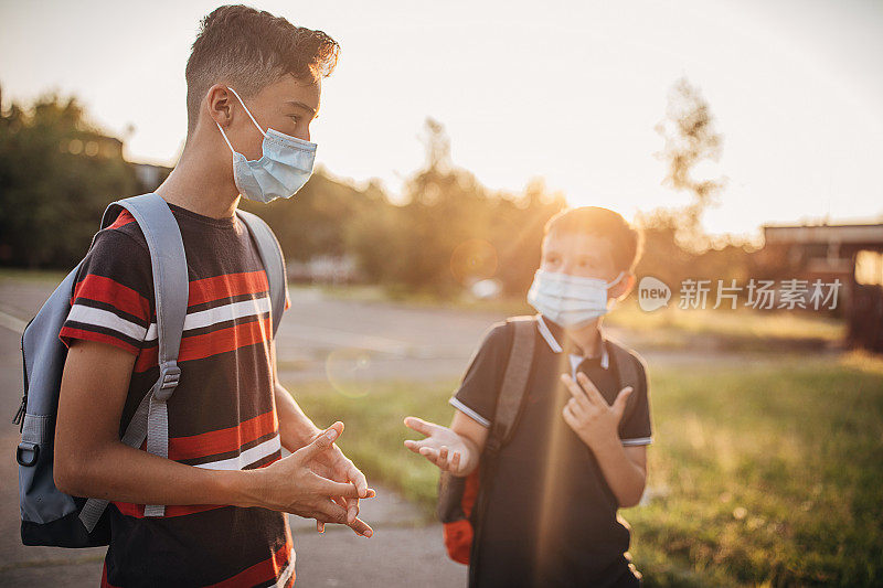 两个戴着医用口罩的男生一起放学回家