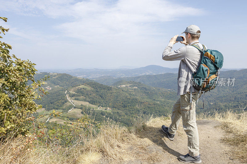 男人在徒步旅行时用手机拍照