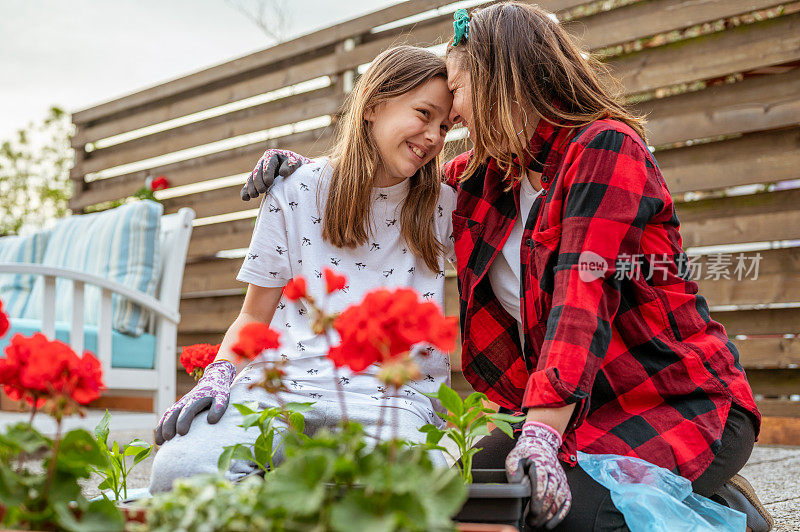 成年妇女和年轻女孩在阳台上种花