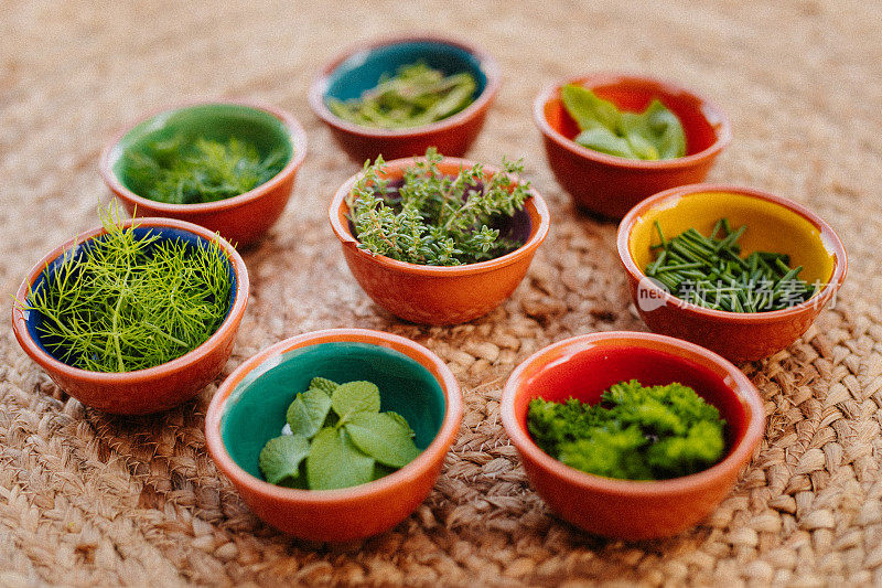 八种不同的香草放在碗里，以乡村拉菲木为背景，主要集中在百里香上