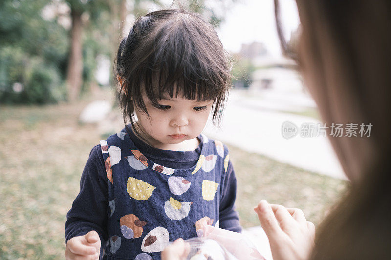 可爱的中国女孩在公园里吃糖果