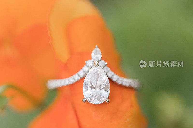橘色花瓣上的泪滴钻石订婚戒指