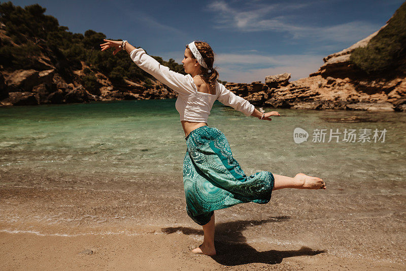瑜伽女人做精神和神圣的舞蹈在阳光沙滩上