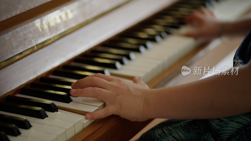 男孩在弹钢琴。家庭教育。近距离观察双手