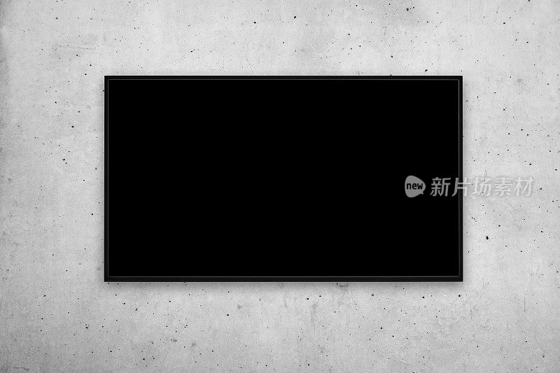 在灰色水泥墙上有一个黑色屏幕的现代壁挂式电视或画框的正面视图