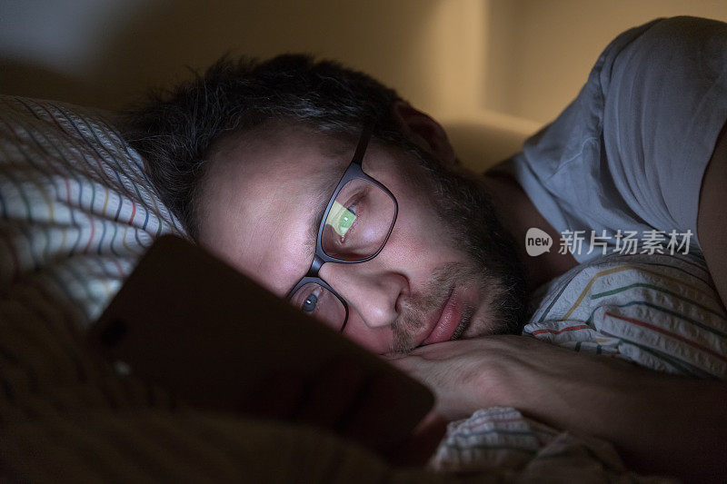 剪裁的肖像成年困倦的男性戴着眼镜在网上冲浪之前做梦