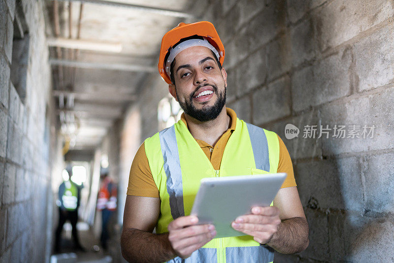 一名工程师在建筑工地使用数码平板电脑