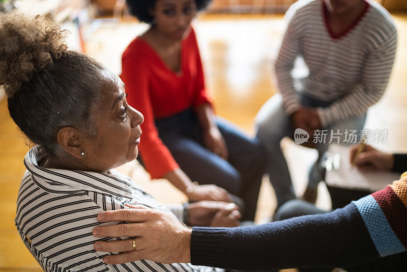 在团体治疗中，一个男人安慰一位年长的女人