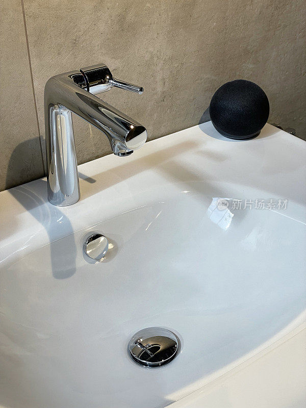 近景的现代浴室与铬，单一的杠杆整体搅拌机水龙头在白色陶瓷水槽，大，石墙瓷砖