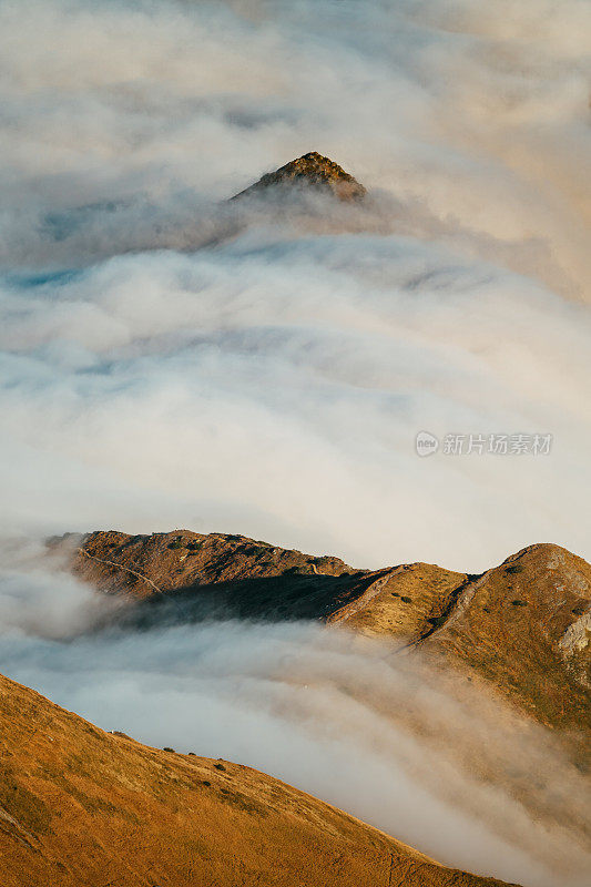 塔特拉山脉和阳光的秋景。云朵飘浮于山峰之上