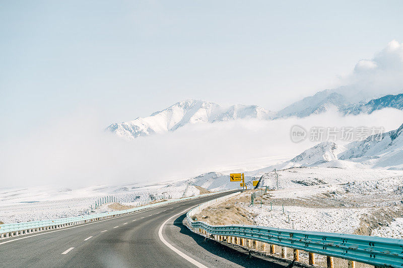 一条高速公路穿过中国新疆的雪山