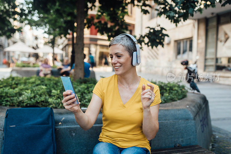 女人享受音乐从她的智能手机