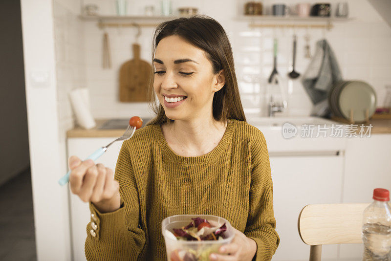 一名年轻女子在家吃蔬菜沙拉的肖像