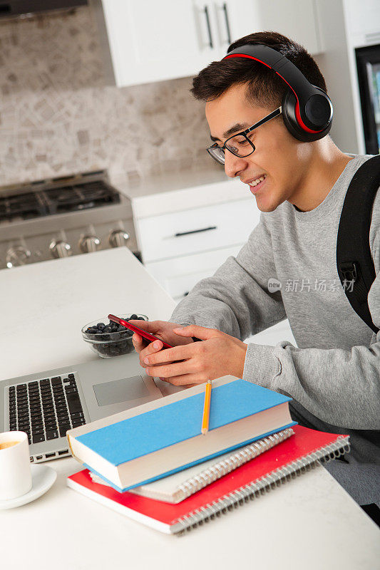 青少年学生在厨房用智能手机发短信