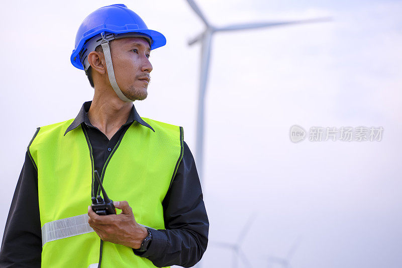 电力工地的蓝领工人。风车。