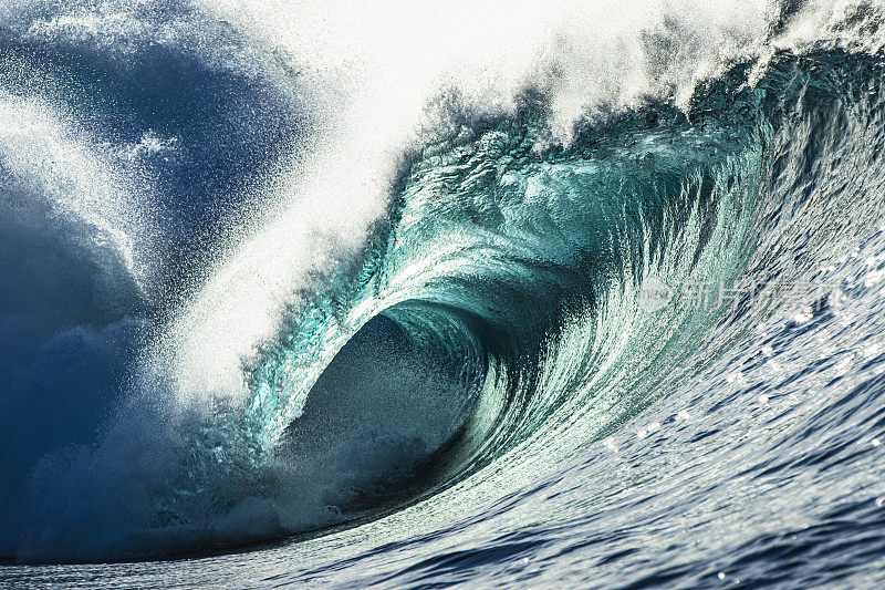 近距离拍摄强有力的蓝绿色海浪拍打礁石的细节