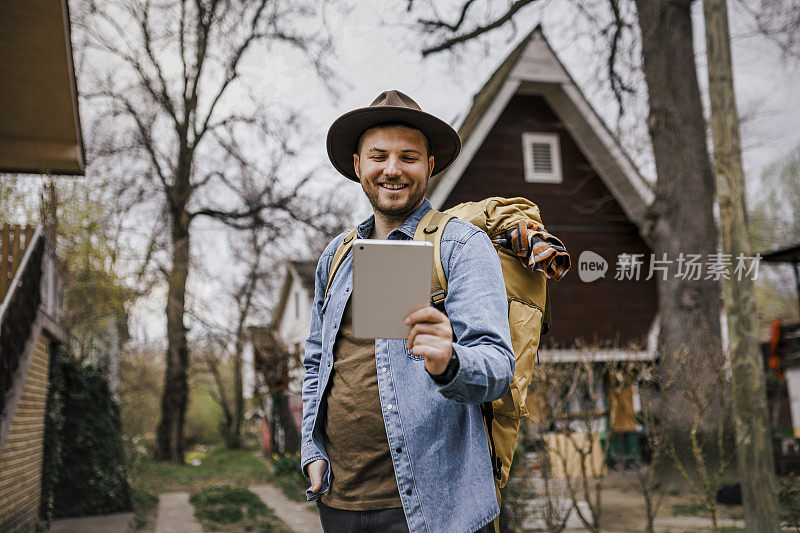 年轻的男性游客在用他的数码平板电脑