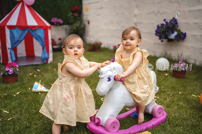 双胞胎姐妹在生日聚会上玩小马玩具
