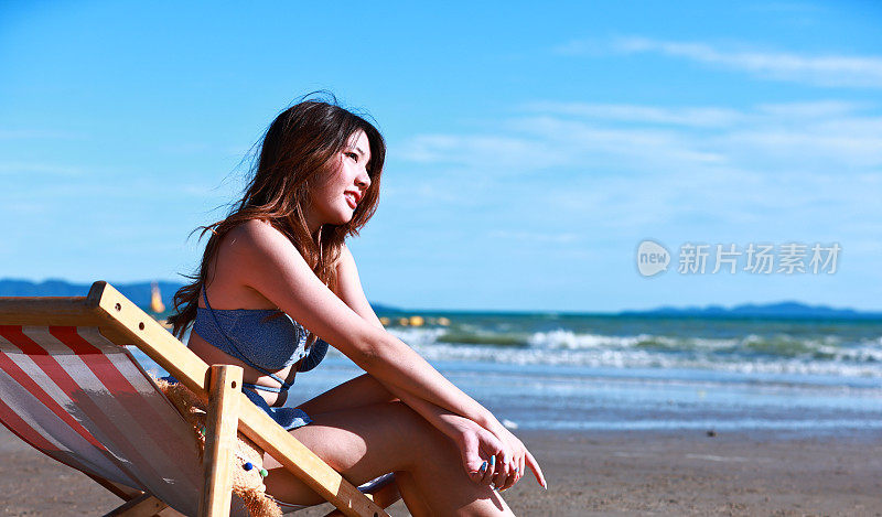 享受年轻女性在沙滩椅上的放松，热带海滩的女性旅行者的生活方式，暑假和旅行的概念