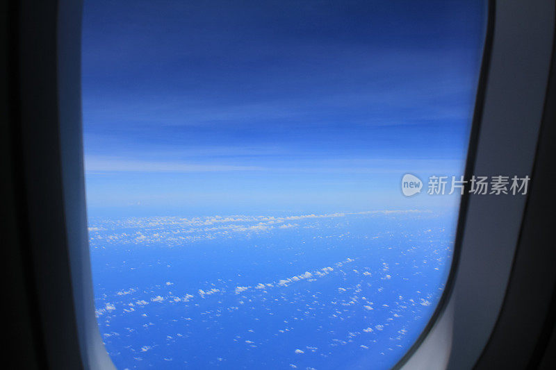 从飞机的窗户往外看。令人惊叹的云景和蓝天。坐飞机旅行。在路上。