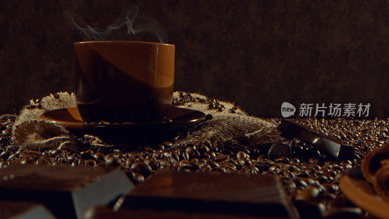 一杯咖啡豆、黑巧克力和肉桂棒的热咖啡