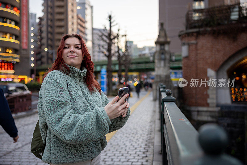 年轻的女游客在桥上拍照