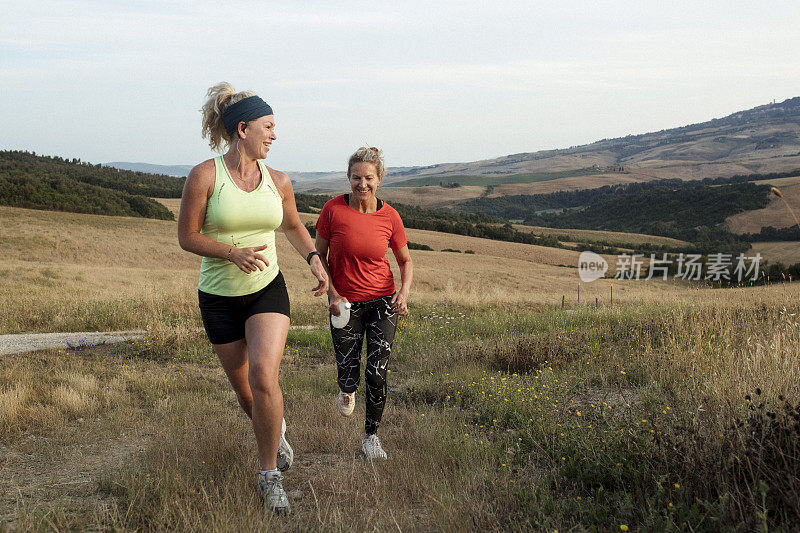 两个成熟的女人在托斯卡纳乡村跑步