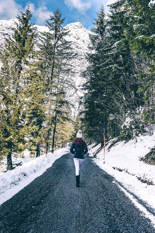 一个年轻女子走在山路上