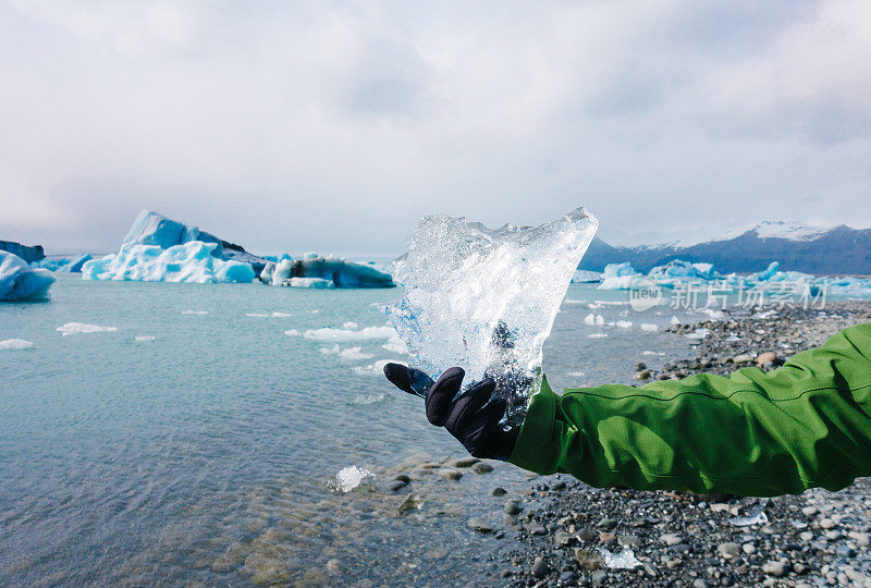 冰岛Jokulsarlon冰川泻湖附近，一名男子手持冰块