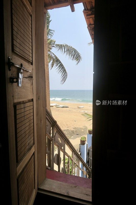 从乡村海滩小屋门口俯瞰渔民的钓鱼海滩，喀拉拉邦，南印度，海滩小屋有海景和阳台露台