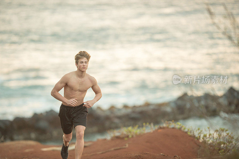 赤裸上身的慢跑者沿着夏威夷的海岸线跑步
