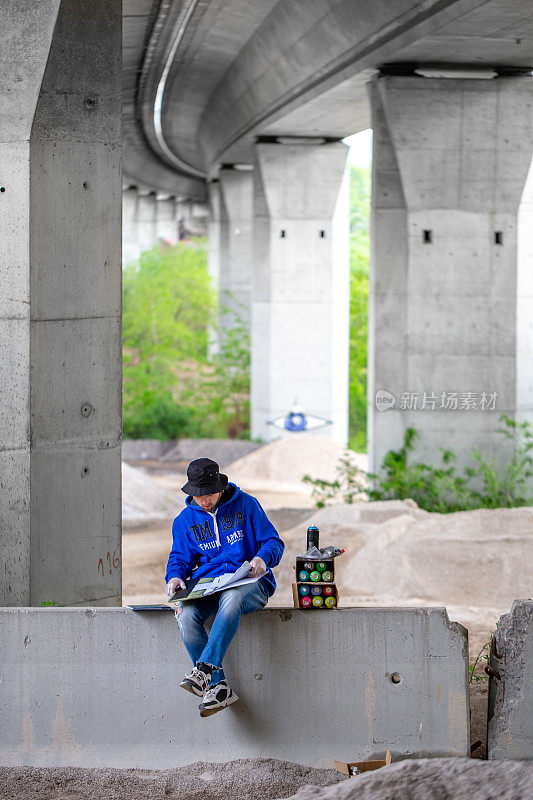 涂鸦艺术家在公路桥下素描