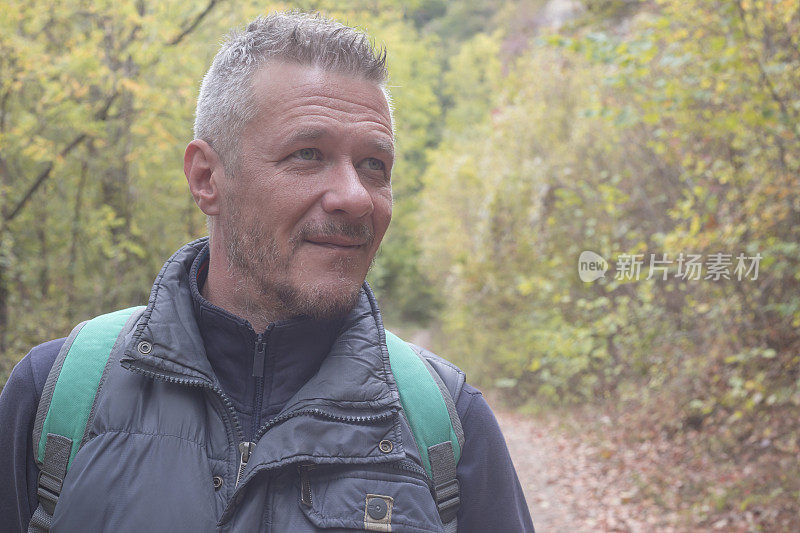 一名成年男子于秋日在美丽的山林中徒步旅行