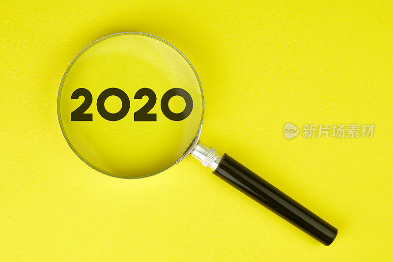 放大镜和2020文字黄色背景股票照片