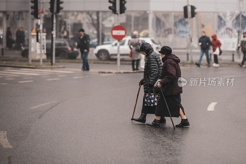 两个老妇人在十字路口非法过马路。