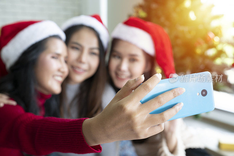 新年或圣诞派对上，亚洲女性朋友团队用智能手机自拍