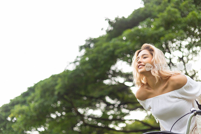 美丽的女人幸福的微笑在公园。快乐放松夏日公园。